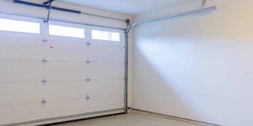An empty garage with door and windows.