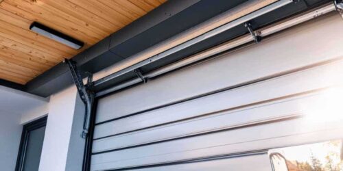 A close-up view of a modern automated garage door with its track system and mechanism visible.