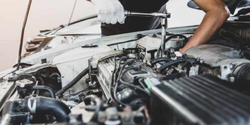 Close-up hand of auto mechanic using wrench to repair a car engine. concepts of car care fix repair service and insurance.