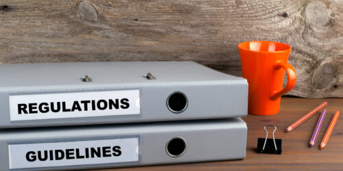 Regulations and Guidelines - two folders on wooden office desk